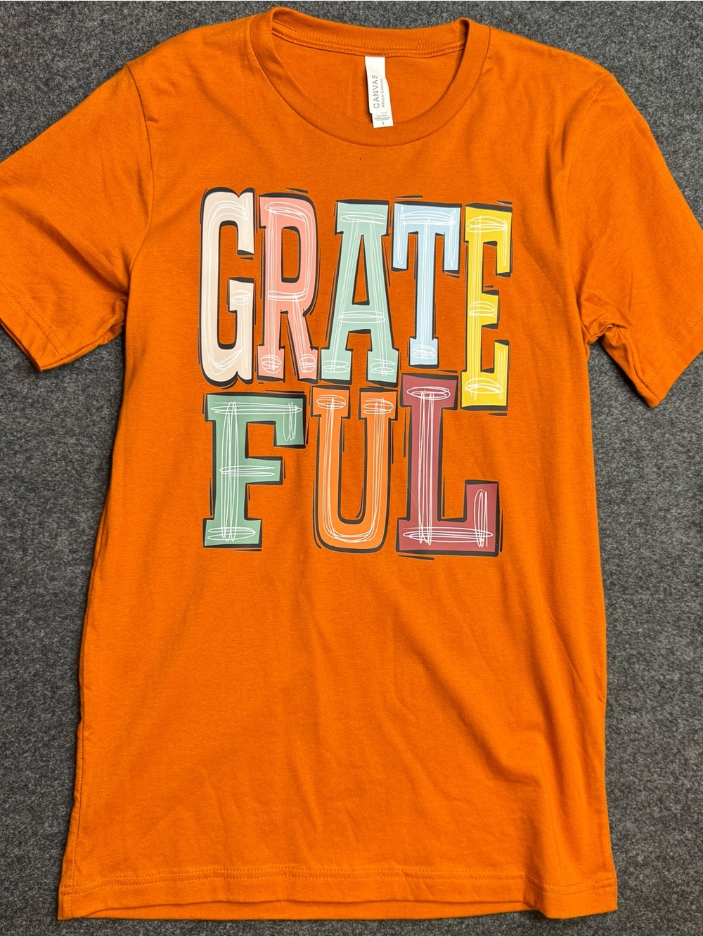 New small Bella Canvas Orange Tee with Colorful GRATEFUL Lettering. Womens